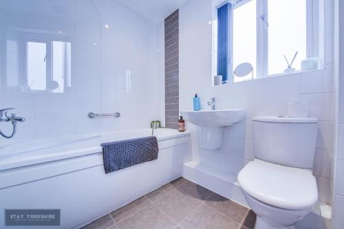 唐克斯特Stay Yorkshire 1st floor Hamilton Mews Apartment的白色的浴室设有卫生间、浴缸和水槽。