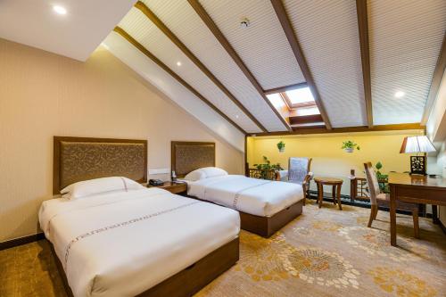 上饶三清山远洲酒店的一间卧室配有两张床、一张桌子和一张桌子