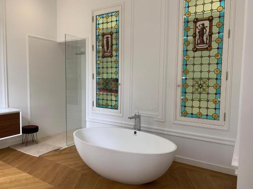 Lacourt-Saint-PierreChambre d'hotes et Table d'hotes Domaine de la terrasse SAS et Gite ANDA Montauban的带浴缸的浴室和彩色玻璃窗