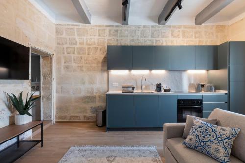 瓦莱塔Valletta Collection - Felix Apartments的客厅里设有带蓝色橱柜和沙发的厨房
