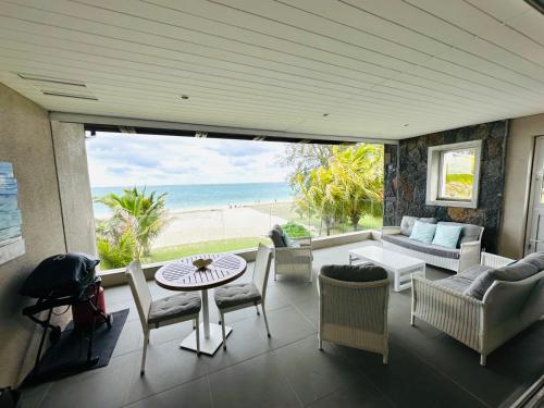 埃斯尼角Pointe d'Esny Beachfront Luxury Apartment的一间享有海滩美景的客厅