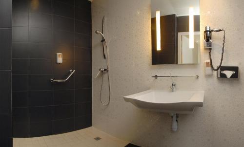 佩皮尼昂Kyriad Prestige Perpignan Centre del Mon的浴室配有盥洗盆和带镜子的淋浴