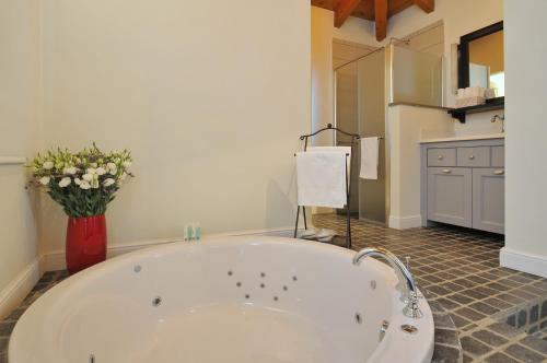 哈德内斯哈德内斯229度假屋的浴室里设有一个大型白色浴缸,花瓶装