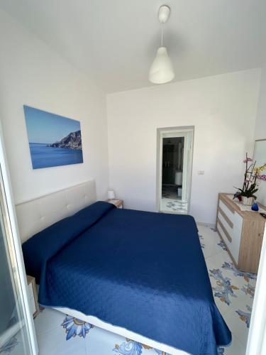 普莱伊亚诺Casa Piccina的一间白色客房内的蓝色床卧室