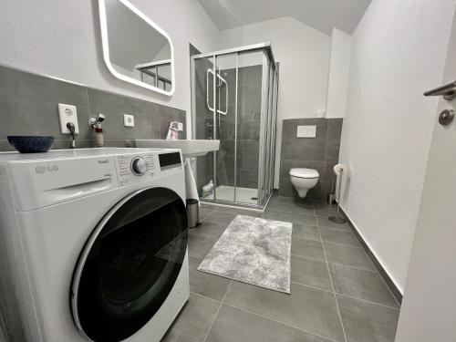 奥芬巴赫Apartment Lili-PS5-Terrace-View-Bright-Kitchen-2xBedroom的浴室内提供白色洗衣机和烘干机
