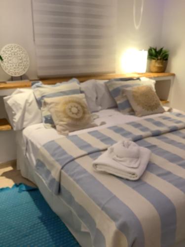 普拉亚登博萨Apartamento Playa Denbossa的一张蓝色和白色的床,上面有两条毛巾