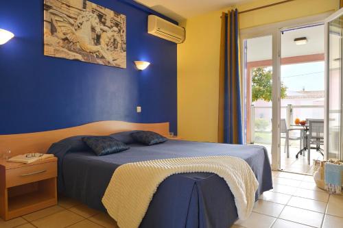 普罗普里亚诺Résidence Villa Romana avec spa的一间卧室配有一张蓝色墙壁的床