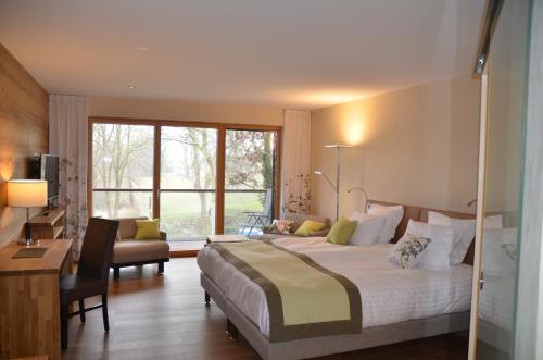 VogelgrunHotel Le Caballin的酒店客房设有一张大床和一张书桌。