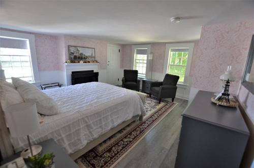 FrancestownBlue Bear inn的卧室配有一张床、一张桌子和椅子