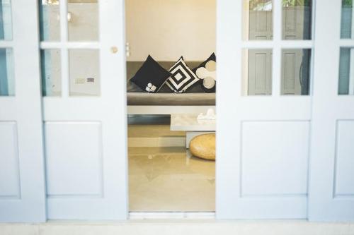 LagunaCosiHome Guesthouse的客厅设有沙发,可通过两扇门欣赏到美景