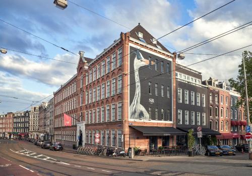 阿姆斯特丹Sir Albert Hotel, part of Sircle Collection的一座大型砖砌建筑,上面有一只大狗