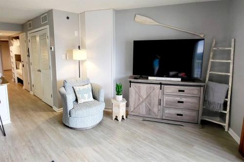 奥兰治比奇Tradewinds 808 - NEW Rental- 1bd/2bath-Luxury Comfort的一间带电视和椅子的客厅