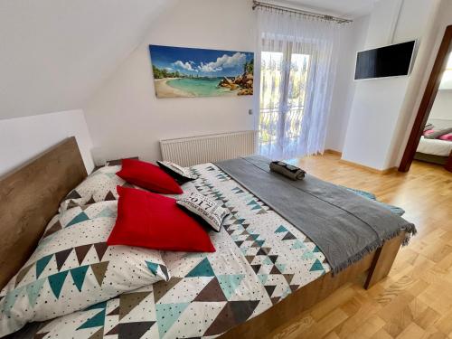 KiczniaDomek w Chmurach的一间卧室配有一张带红色枕头的床