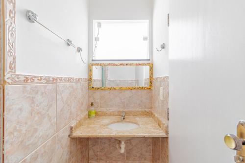 瓜拉久巴GB07 Ótima Casa 4 Suítes com Piscina em Guarajuba的一间带水槽和镜子的浴室