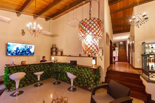 圣希尔Ámbar Hostel San Gil的餐厅的酒吧,有绿色的墙壁