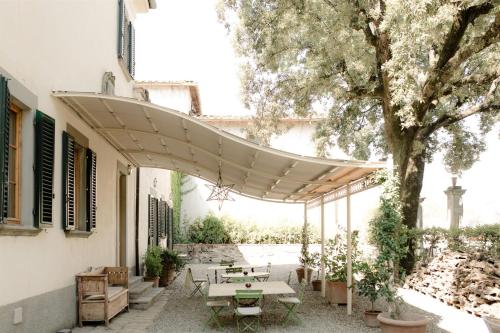 基安蒂格雷夫Villa de' Ricci Rignana di Sveva Rocco di Torrepadula的一个带野餐桌和树的庭院