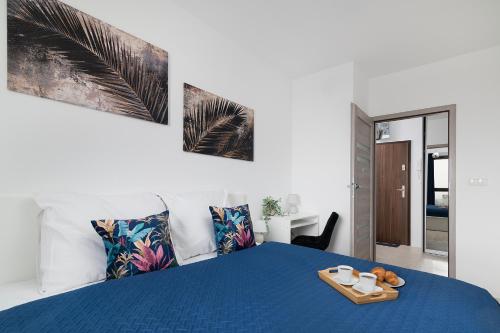 卢布林Easy Rent Apartments - Metropolitan 75的一间卧室配有一张蓝色的床,上面有托盘