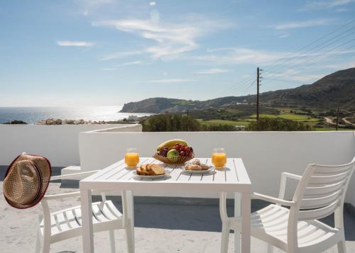 ProvatasSarantis Suites & Apartments的阳台上配有带食品和饮料的白色桌子
