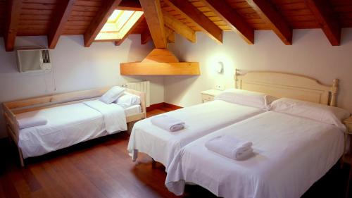 蒙达卡Hotel Branka的一间卧室设有两张带白色床单的床和窗户。