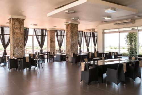 AgreloVillas Del Malbec Lodges的餐厅设有桌椅和大窗户。
