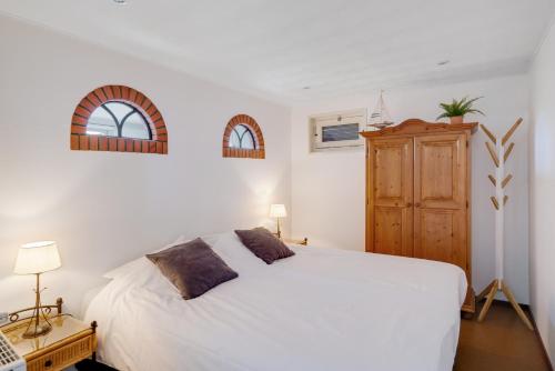 埃赫蒙德·安登胡夫't Zwanennest的卧室配有白色的床和木制橱柜。