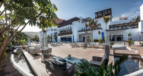甘迪亚海滩富埃特文图公主酒店的一个带游泳池、椅子和棕榈树的度假村