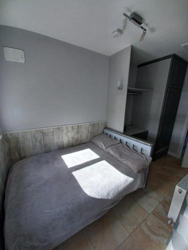 特拉利Eva Lodge的一间卧室配有一张带灰色毯子的床