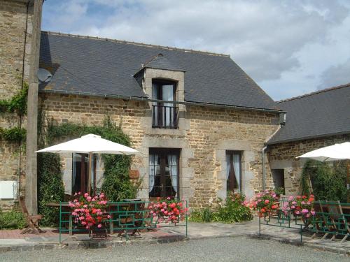 Les Champs-GérauxGîte Cerise - Les Gîtes de la Lohuas的前面有桌子和伞的建筑