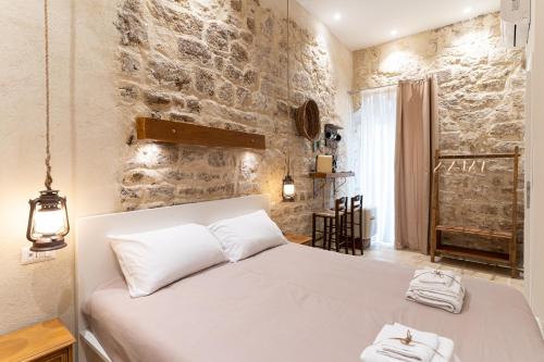 巴里Suite Torre Arcobasso的卧室配有白色的床和石墙