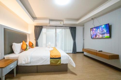 拜县Peacock De Pai Hotel的卧室配有一张床,墙上配有电视。