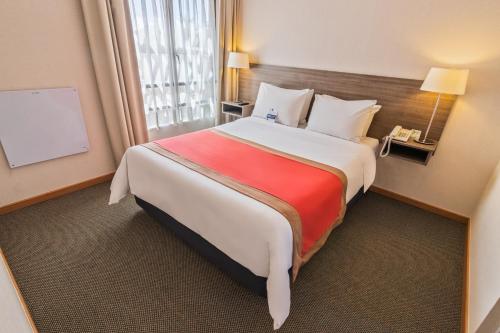 卡拉马卡拉马吉尔公寓式酒店的一间设有大床和窗户的酒店客房