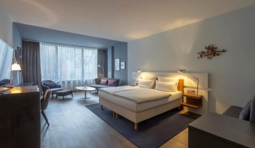 杜塞尔多夫Clayton Hotel Düsseldorf City Centre的一间卧室设有一张床和一间客厅。