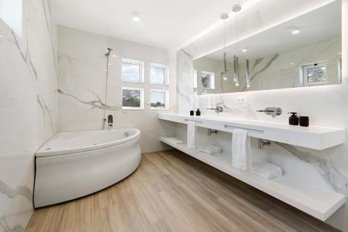 特罗亚Soltroia Beach Court Villa的白色的浴室设有浴缸和水槽。