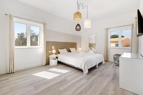 特罗亚Soltroia Beach Court Villa的白色的卧室设有白色的床和窗户。
