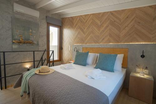 霍拉斯法基翁Jacuzzi maisonette in Sfakia center 'New 2023'的一间卧室配有一张大床,上面有帽子