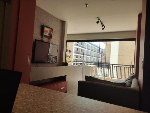 塔瓜汀加Taguá life apartamento amplo moderno e encantador的客厅设有大窗户和电视。
