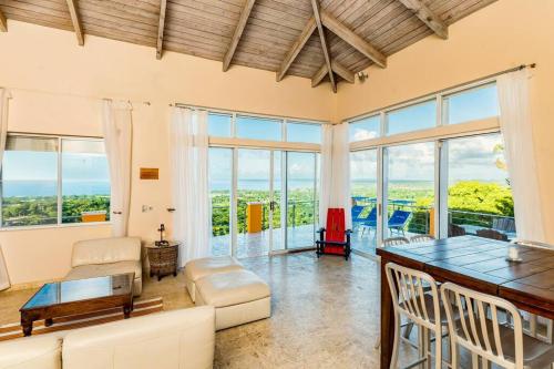 别克斯Vieques Villa Gallega - Oceanview w/Infinity Pool的客厅配有桌椅和窗户。