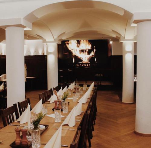 EmmeringGasthof & Hotel Bichler的一间长长的用餐室,配有一张长桌和白色餐巾
