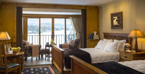 普莱西德湖镜湖度假&spa酒店的酒店客房设有一张床和一个阳台。