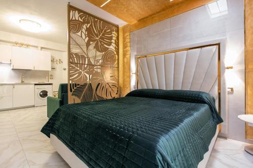 博洛尼亚FASHION APARTMENT GOLD Bologna的一间卧室配有一张带绿色棉被的大床