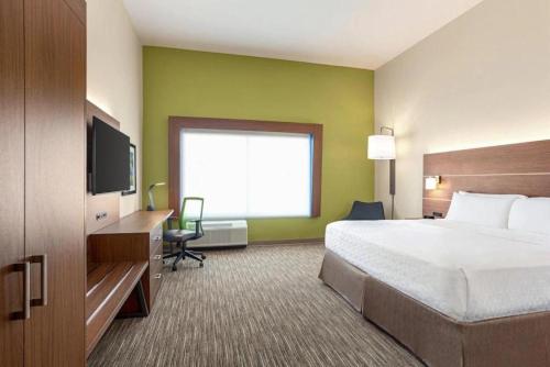 普弗拉热维尔Holiday Inn Express & Suites Austin North - Pflugerville, an IHG Hotel的配有一张床和一台平面电视的酒店客房