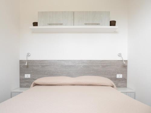 莫诺波利Santo Stefano Village的一间卧室配有一张带木制床头板的床