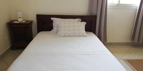 ChironguiSuite Villa au bord de la mer chez Saloua的一张带白色床单和枕头的床