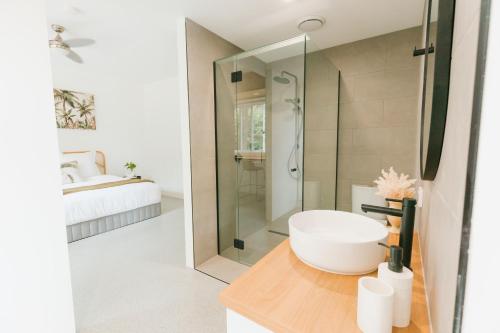 Maroochy RiverTinarra Treetops的一间带水槽和玻璃淋浴的浴室