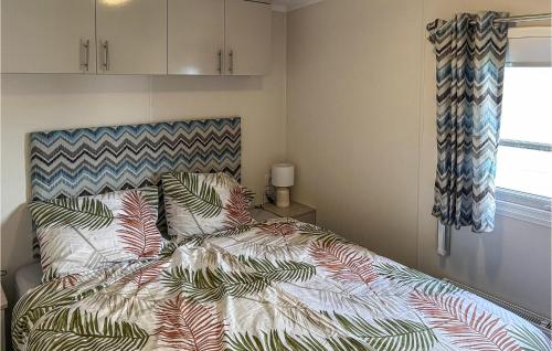 ScherpenisseNice Home In Scherpenisse的一间卧室配有一张带五颜六色棉被的床