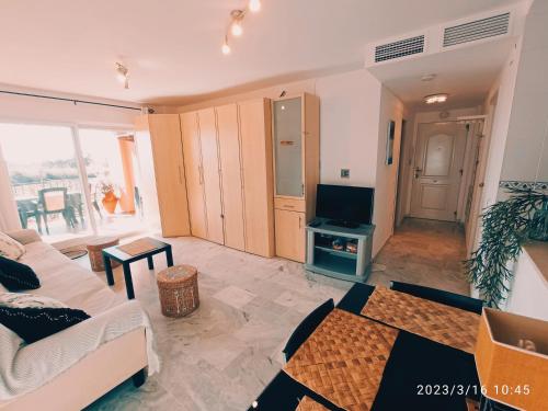 马尼尔瓦APARTAMENTOS LOS HIDALGO GOLF的带沙发和电视的客厅