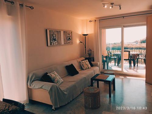 马尼尔瓦APARTAMENTOS LOS HIDALGO GOLF的客厅配有沙发和桌子