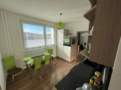 斯维特Svit apartment High Tatras的一间厨房,内设一张桌子和绿色椅子