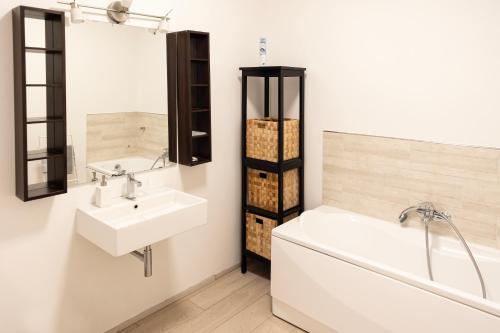 米兰Elegante e Spazioso Quadrilocale in Porta Venezia的带浴缸、水槽和浴缸的浴室