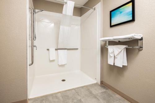 劳埃德明斯特Home Inn and Suites Lloydminster的带淋浴和白色毛巾的浴室